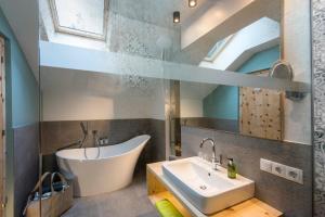 a bathroom with a white tub and a sink at Naturhotel Saalerwirt in San Lorenzo di Sebato +41 photos