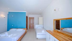 a bedroom with two beds and a blue wall at Sole'n Blu in Kaş