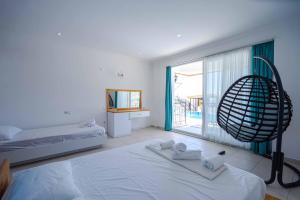 a white bedroom with a bed and a large window at Sole'n Blu in Kaş