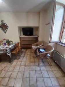 a living room with a table and chairs and a television at Marmotte - Apartment near the cable car in La Grave in La Grave