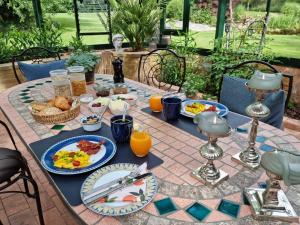 a breakfast table with food and orange juice at Liebhaveri i særklasse in Årup