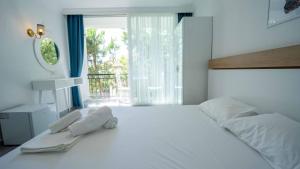 a bedroom with a large white bed with a window at Sole'n Blu in Kaş