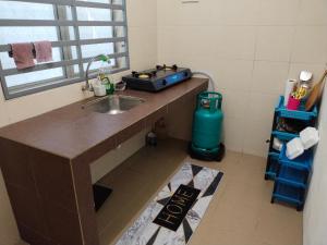 a kitchen counter with a sink and a window at WAFID HOMESTAY SERI ISKANDAR in Seri Iskandar