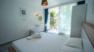 a bedroom with a large white bed and a window at Sole'n Blu in Kaş