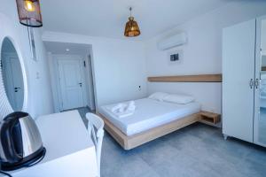a white bedroom with a bed and a table and chairs at Sole'n Blu in Kaş