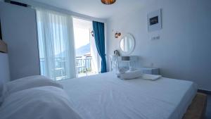 a bedroom with a large white bed with a large window at Sole'n Blu in Kaş