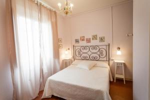 ein Schlafzimmer mit einem weißen Bett und einem Kronleuchter in der Unterkunft Il Piccolo Verde in Terranuova Bracciolini