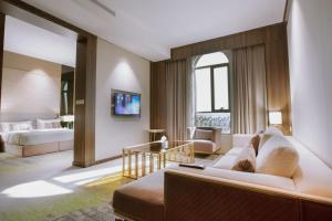 um quarto de hotel com uma cama e um sofá em ازر احد رفيدة em Ahad Rafidah