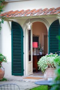 an entry to a house with green doors and flowers at Il Piccolo Verde in Terranuova Bracciolini
