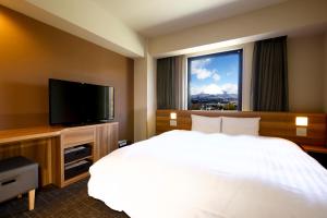 Habitación de hotel con cama y TV de pantalla plana. en Dormy Inn Express Fujisan Gotemba, en Gotemba