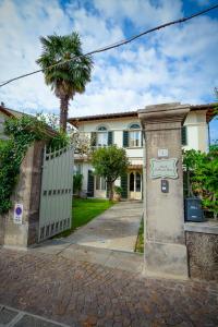 a house with a gate and a palm tree at Il Piccolo Verde in Terranuova Bracciolini