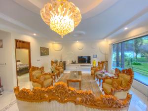 a large living room with a chandelier and a table and chairs at Villa Andalus 1&2 in Puncak