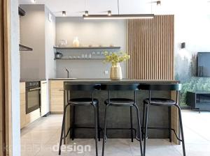 kuchnia z czarnym blatem ze stołkami w obiekcie Apartament Przystań Iława Green w Iławie