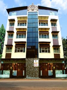 un edificio blanco alto con un reloj en él en Soukyam Hotel en Calcuta