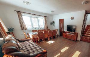 a living room with a couch and a table with chairs at Casa Ianis in Arieşeni