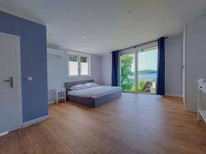 a bedroom with a bed and a large window at Herta House in Dorotowo