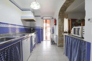 una cucina blu e bianca con lavandino e forno a microonde di Casa Fina Espeja (Salamanca) a Espeja