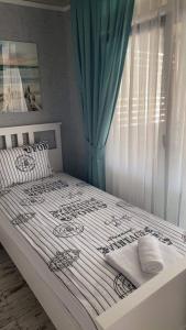 La Veranda Sinemorets في سينيموريتس: غرفة نوم بسرير ابيض وستارة زرقاء