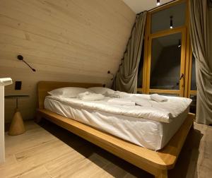 a bed with a white bedspread and pillows in a room at Buhta Vikingiv in Vodniki