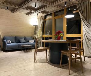 sala de estar con sofá, mesa y sillas en Buhta Vikingiv, en Vodniki