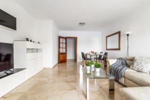 Home2Book Fantastic Design Apartment Las Palmas في لاس بالماس دي غران كاناريا: غرفة معيشة مع أريكة وطاولة