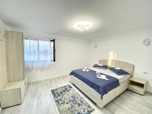1 dormitorio con 1 cama con sábanas azules y blancas en Casa Munteanu, en Mila Douăzeci şi Trei