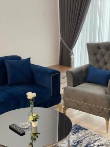 a living room with a blue couch and a table at Modern 1-bedroom apartment near Mall of Istanbul - 105 gunesli 10 in Istanbul