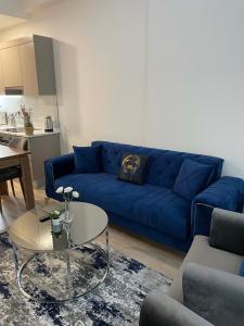 a living room with a blue couch and a table at Modern 1-bedroom apartment near Mall of Istanbul - 105 gunesli 10 in Istanbul