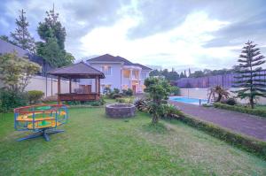 a yard with a playground in front of a house at Villa Andalus 1&2 in Puncak