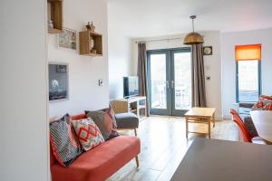 a living room with a red couch and a table at 7 Pen y Bont in Abersoch