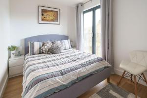 a bedroom with a bed and a chair and a window at 7 Pen y Bont in Abersoch