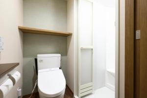 a small bathroom with a toilet and a sink at Dormy Inn Express Fujisan Gotemba in Gotemba