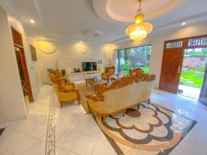a living room with yellow chairs and a table at Villa Andalus 1&2 in Puncak