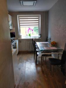 uma cozinha com uma mesa de jantar e uma janela em 2-ju kambariu butas em Ignalina