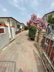 a brick walkway in front of a house with a fence at Bilo Lu Rattali in San Teodoro