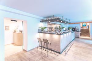a bar in a room with two stools at Boutique Wellnesshotel Landmann in Steinen