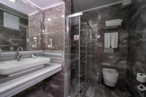 a bathroom with a sink and a toilet at Lykia Botanika Beach Fun & Club - All Inclusive in Fethiye