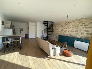 een woonkamer met een bank en een tafel bij La grange in Saint-Laurent-sur-Sèvre