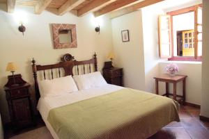 a bedroom with a large bed and a window at Muiño das Cañotas in O Lourido