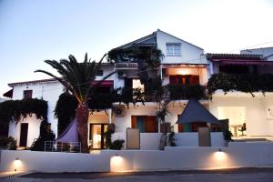 un edificio blanco con una palmera delante en Galini Studios & Apartments, en Sougia