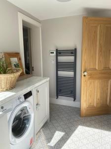 a laundry room with a washing machine and a door at Redhills Mohill in Rivers Town
