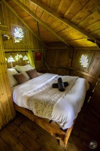un letto in una camera in una casa di legno di Le Petit Moulin du Rouvre a Saint-Pierre-de-Plesguen
