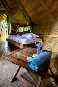 - une chambre avec 2 lits et une table dans une cabane dans les arbres dans l'établissement Le Petit Moulin du Rouvre, à Saint-Pierre-de-Plesguen