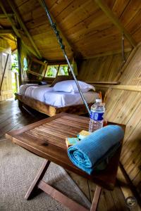 a room with two beds and a table in a tree house at Le Petit Moulin du Rouvre in Saint-Pierre-de-Plesguen