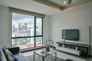 a living room with a couch and a large window at Casa Residency Apartment in Kuala Lumpur