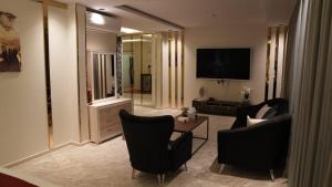 a living room with two chairs and a television at آكام للشقق المخدومة أحد رفيدة in Ahad Rafidah