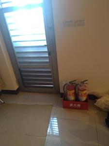 Zimmer mit einer Tür und einer Box auf dem Boden in der Unterkunft mei hao min su in Insel Nangan