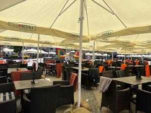 a restaurant with tables and chairs under a large umbrella at Family & Business Sauna Apartments Sienkiewicza No1 Centrum Plac Lliteratów- Piękny Apartament - 1 Bedroom with Private Sauna, Bath with Hydromassage, Parking in Kielce