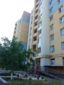 two tall buildings with a tree in front of them at Apartment Mlynivs'ka 29 A in Rivne