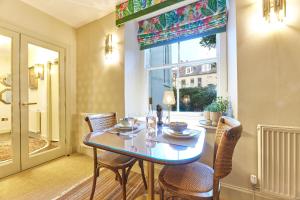 een eetkamer met een tafel en stoelen en een raam bij Cinnabar: Luxury, Couple's Nook in Historic Walls. in Berwick-Upon-Tweed